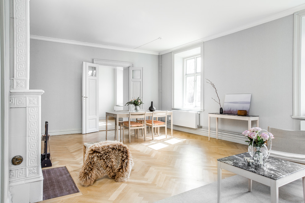Foto på ett stort minimalistiskt vardagsrum, med vita väggar och ljust trägolv