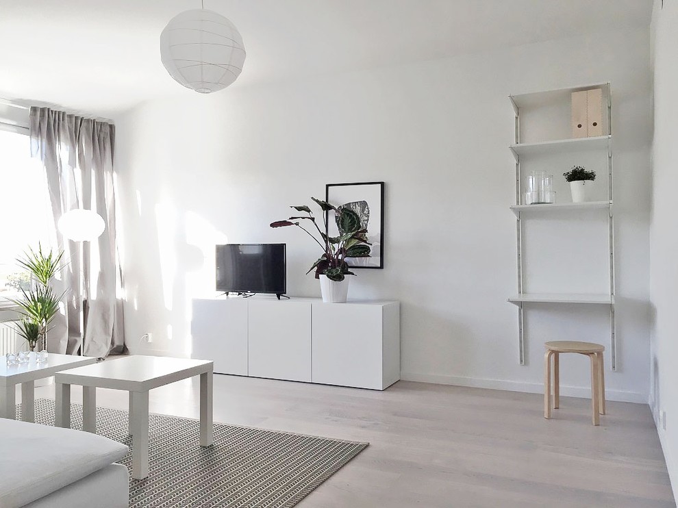 Exempel på ett skandinaviskt separat vardagsrum, med vita väggar, ljust trägolv och en fristående TV