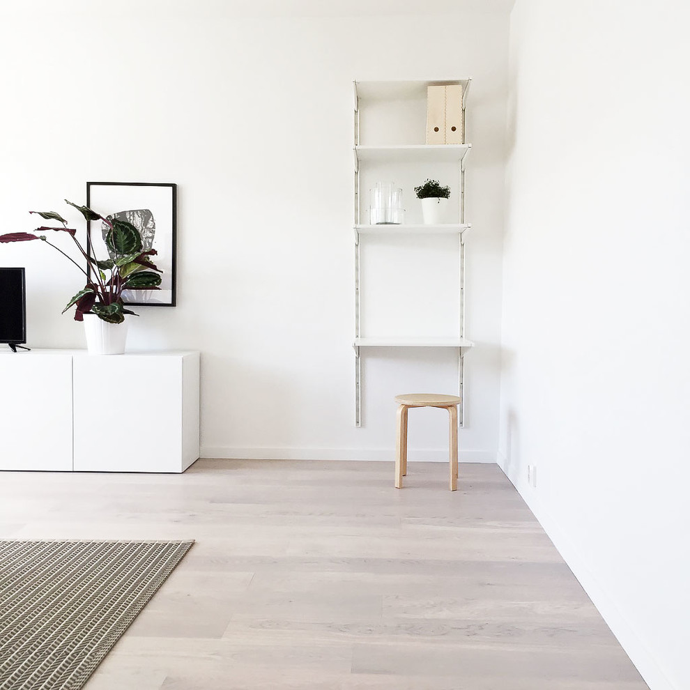 Exempel på ett nordiskt separat vardagsrum, med vita väggar, ljust trägolv och en fristående TV