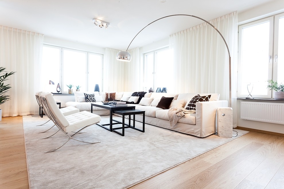 Esempio di un ampio soggiorno design aperto con pareti bianche, nessuna TV, sala formale, parquet chiaro, pavimento marrone e tappeto