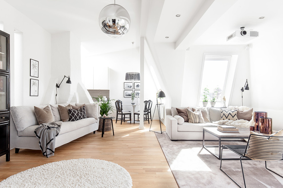 На фото: большая открытая, парадная гостиная комната в скандинавском стиле с белыми стенами, светлым паркетным полом и бежевым полом без камина, телевизора с