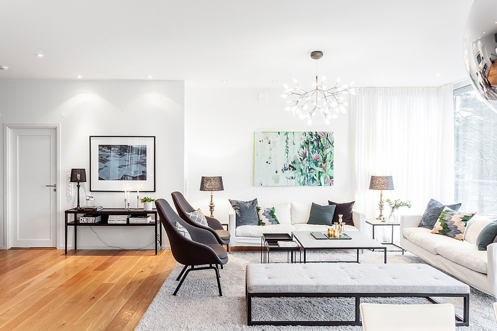 Ispirazione per un grande soggiorno design aperto con pareti bianche, pavimento in legno massello medio, nessuna TV e pavimento marrone