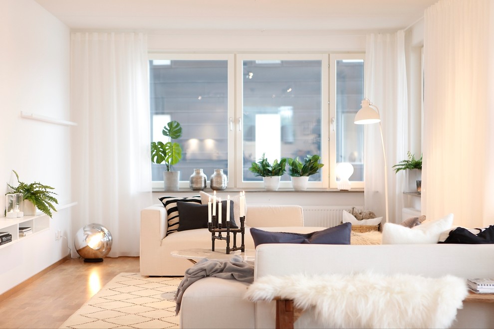 Свежая идея для дизайна: изолированная гостиная комната среднего размера в скандинавском стиле с белыми стенами, паркетным полом среднего тона и коричневым полом без телевизора - отличное фото интерьера