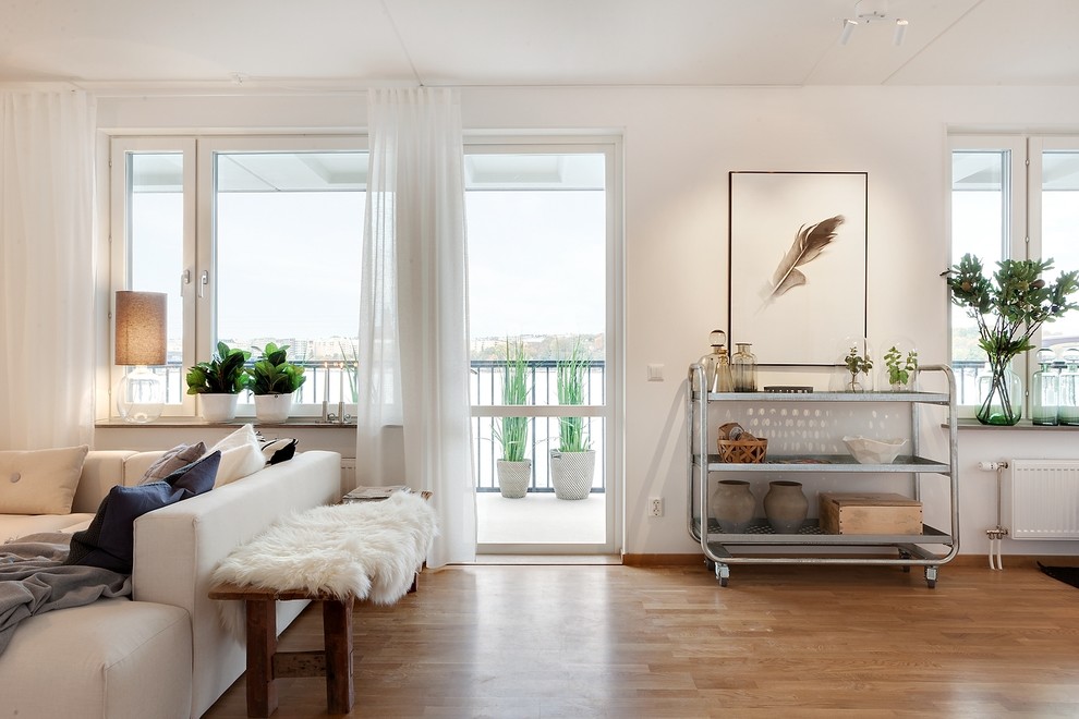 Esempio di un soggiorno scandinavo di medie dimensioni e chiuso con pareti bianche, pavimento in legno massello medio, nessuna TV e pavimento marrone