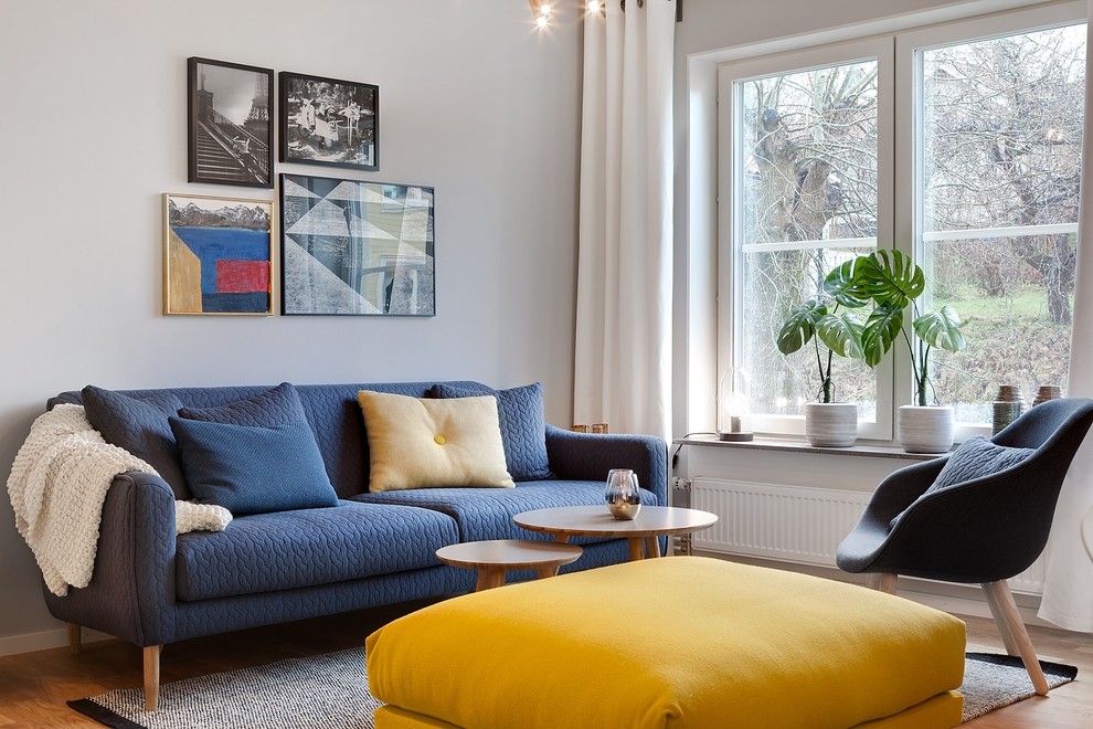 Mittelgroßes, Abgetrenntes Nordisches Wohnzimmer mit grauer Wandfarbe, hellem Holzboden und braunem Boden in Göteborg