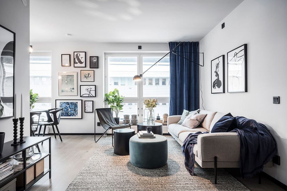 Пример оригинального дизайна: большая открытая гостиная комната в скандинавском стиле с белыми стенами, светлым паркетным полом и серым полом без камина, телевизора