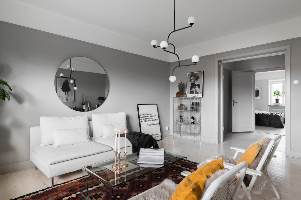 Bild på ett skandinaviskt separat vardagsrum, med grå väggar, ljust trägolv och beiget golv