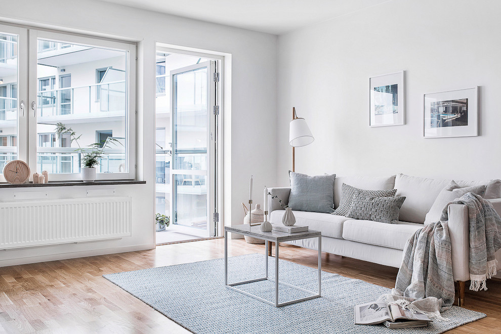 Diseño de salón para visitas abierto escandinavo de tamaño medio sin chimenea y televisor con paredes blancas y suelo de madera clara