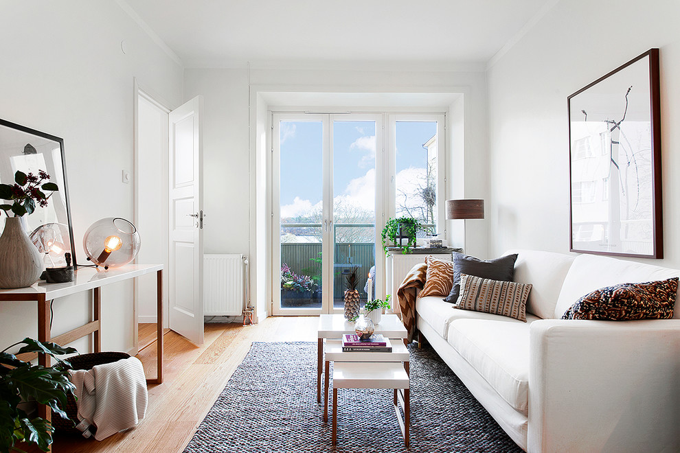 Стильный дизайн: большая парадная, изолированная гостиная комната в скандинавском стиле с белыми стенами и паркетным полом среднего тона без камина, телевизора - последний тренд