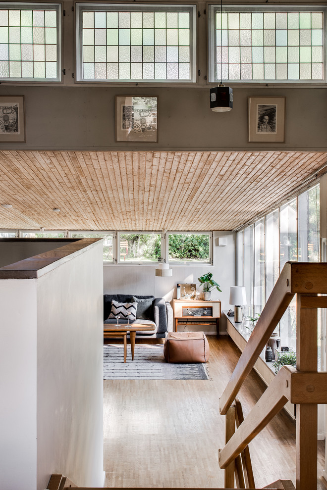 Idee per un grande soggiorno minimalista aperto con pareti bianche e pavimento in legno massello medio