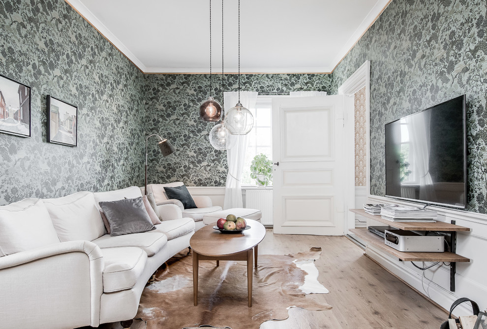 Foto di un soggiorno classico chiuso con sala formale, pareti verdi, parquet chiaro, TV a parete e pavimento beige