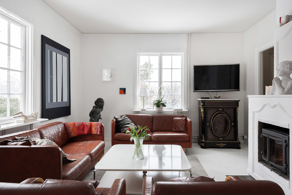 Inspiration för minimalistiska separata vardagsrum, med vita väggar, en standard öppen spis, en väggmonterad TV och vitt golv