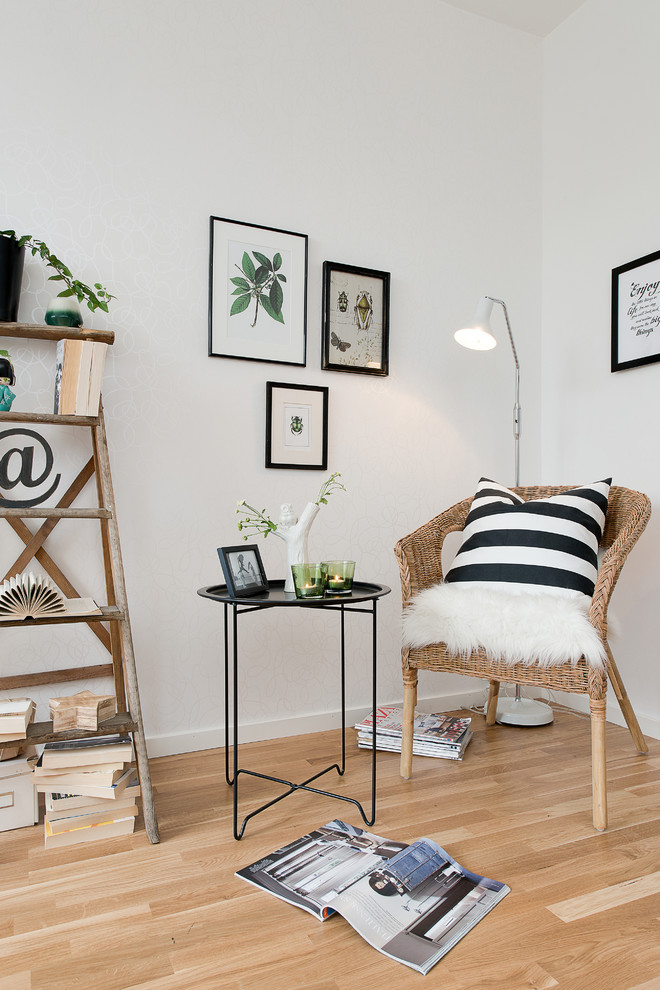 Стильный дизайн: гостиная комната в скандинавском стиле с с книжными шкафами и полками, белыми стенами и светлым паркетным полом без телевизора - последний тренд