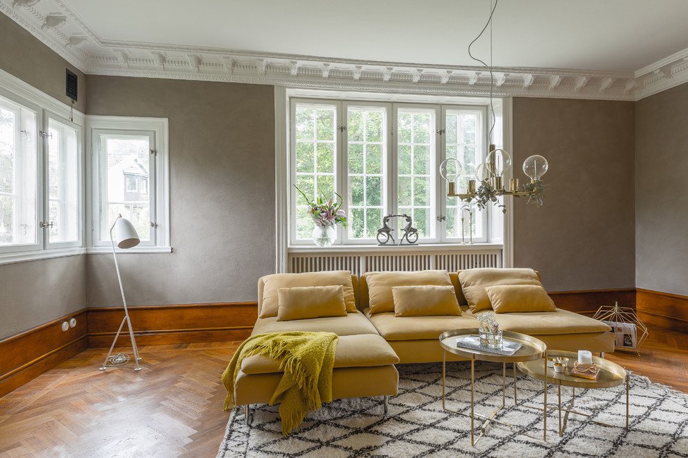 Modelo de salón clásico con paredes grises y suelo de madera en tonos medios