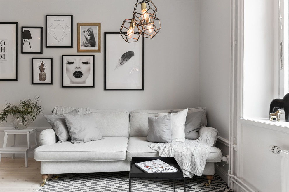 Mid-sized danish formal light wood floor living room photo in Stockholm with white walls