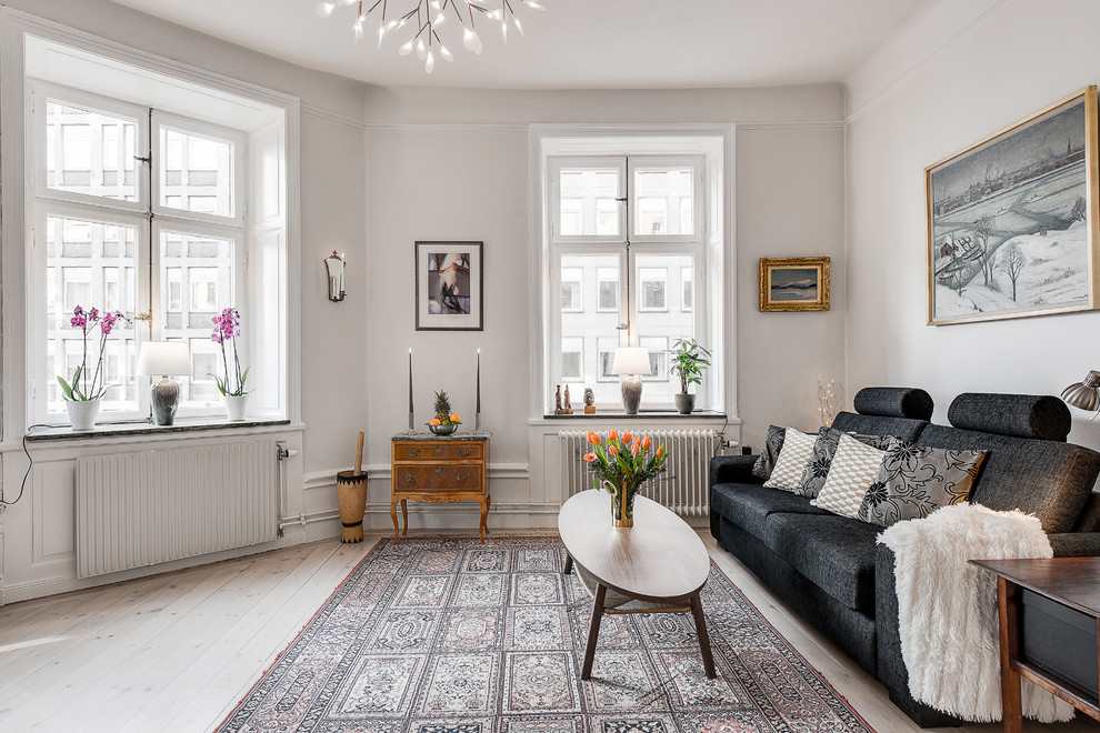 Photo of a medium sized scandi formal living room in Stockholm with white walls, light hardwood flooring and no fireplace.