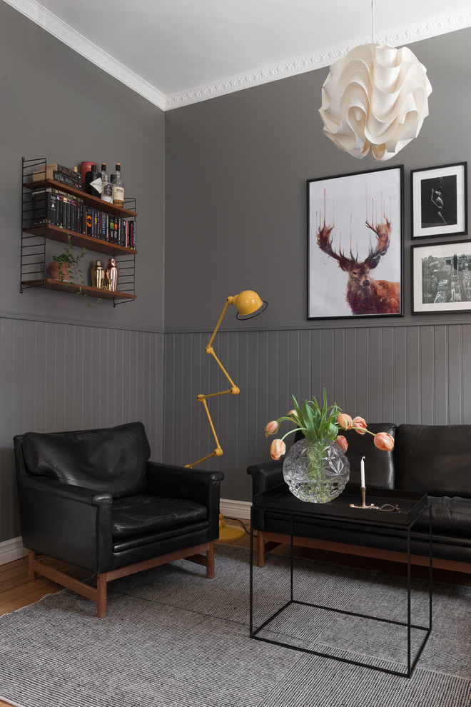 Imagen de salón abierto nórdico de tamaño medio sin chimenea y televisor con paredes grises y suelo de madera en tonos medios