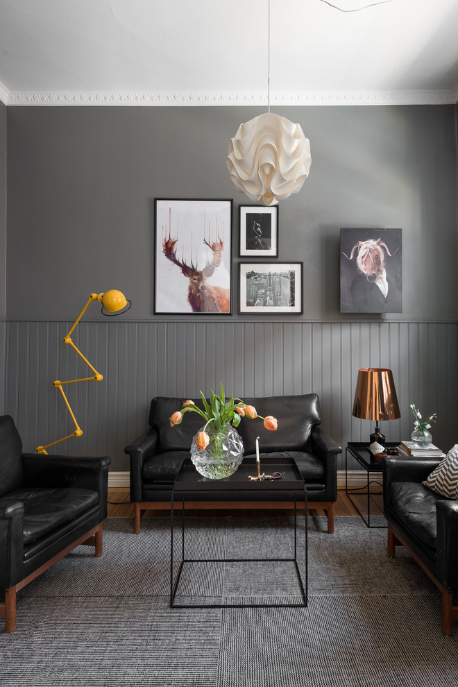 Ejemplo de salón abierto nórdico de tamaño medio sin chimenea y televisor con paredes grises y suelo de madera en tonos medios