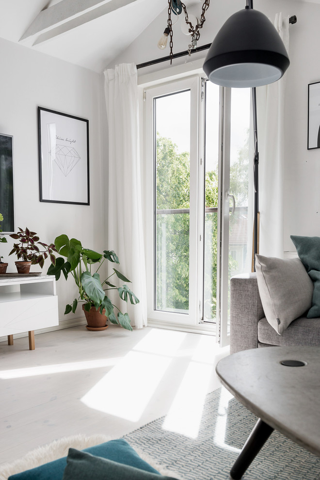 Design ideas for a medium sized scandinavian mezzanine living room in Gothenburg with white walls, light hardwood flooring and a wall mounted tv.