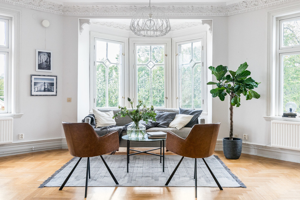 Large scandinavian formal open plan living room in Gothenburg with white walls, medium hardwood flooring, no fireplace and no tv.