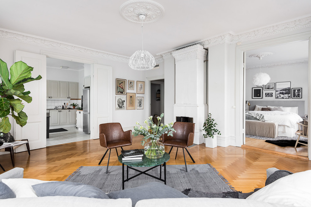 Modelo de salón para visitas abierto y gris y blanco escandinavo extra grande sin chimenea y televisor con paredes blancas y suelo de madera en tonos medios