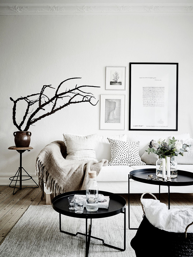 Foto på ett mellanstort minimalistiskt vardagsrum, med vita väggar och ljust trägolv