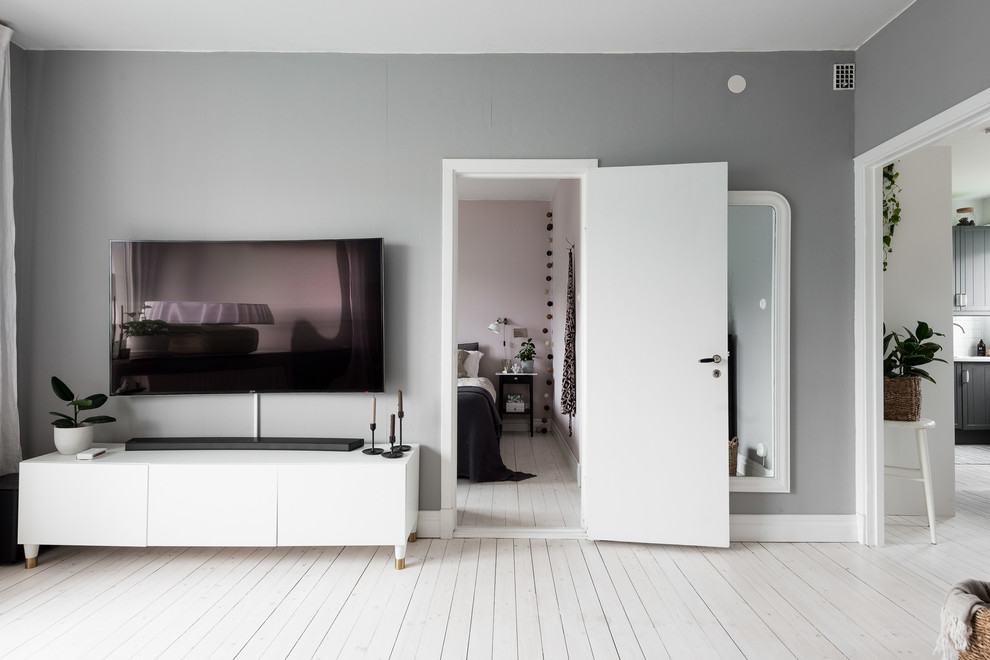 Skandinavisk inredning av ett mellanstort separat vardagsrum, med grå väggar, ljust trägolv och vitt golv