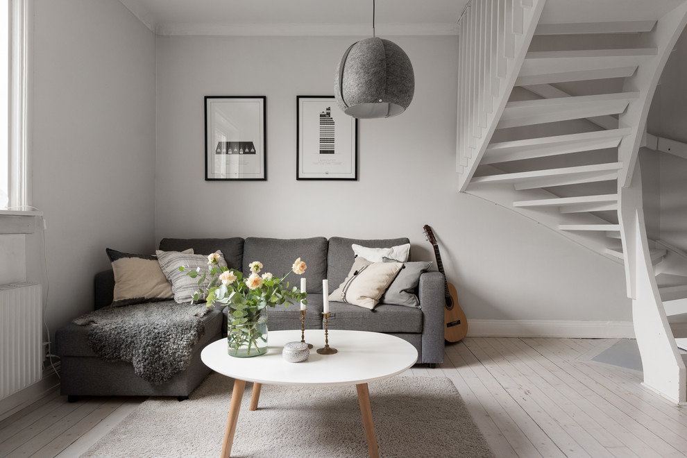 Idee per un soggiorno nordico di medie dimensioni con pareti grigie, parquet chiaro e pavimento beige