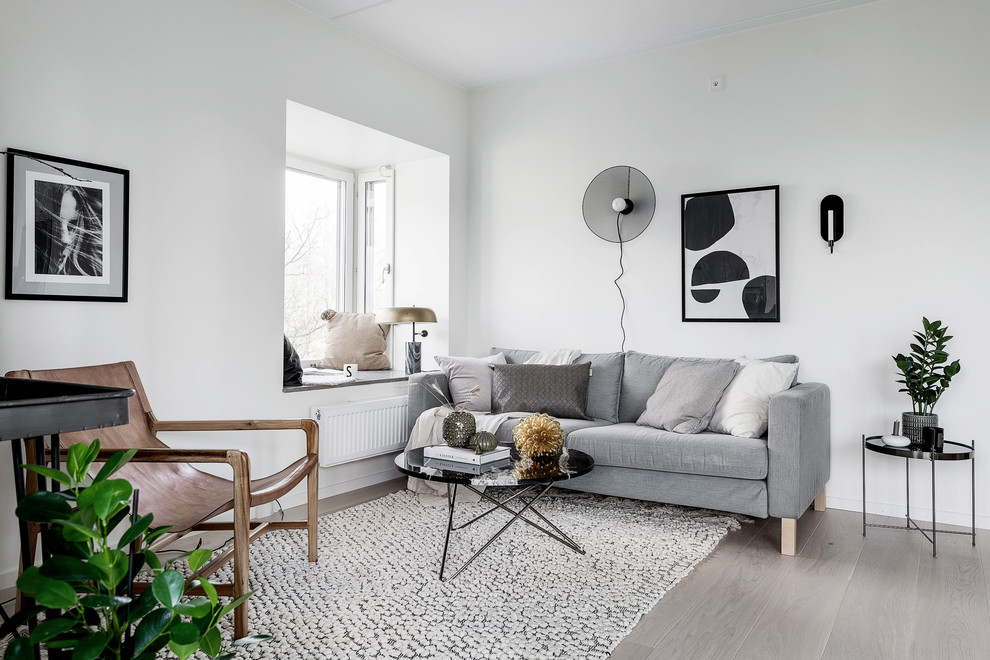 Foto di un soggiorno scandinavo di medie dimensioni e aperto con pareti bianche e parquet chiaro