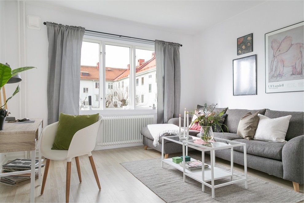 Photo of a scandi enclosed living room in Gothenburg with white walls, light hardwood flooring and beige floors.