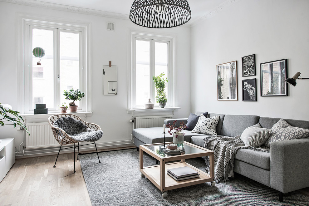 Foto di un soggiorno scandinavo chiuso con pareti bianche, parquet chiaro e pavimento beige