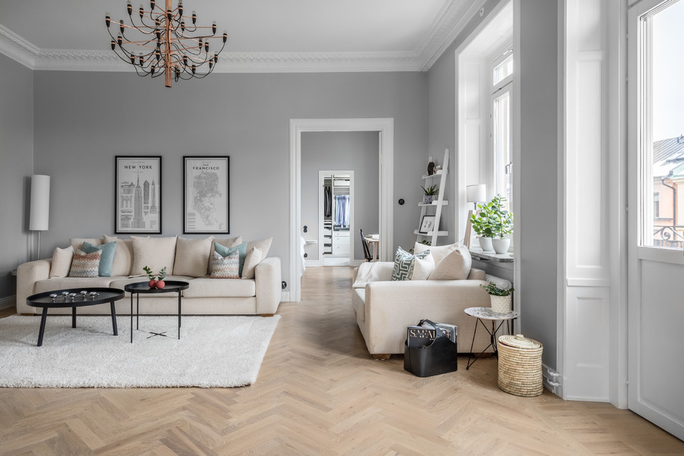 Стильный дизайн: большая парадная, изолированная гостиная комната в скандинавском стиле с серыми стенами и светлым паркетным полом - последний тренд