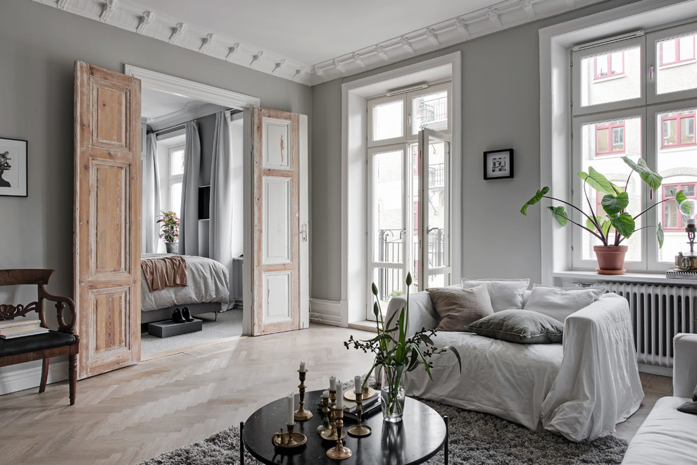 Modelo de salón escandinavo con paredes grises y suelo de madera clara