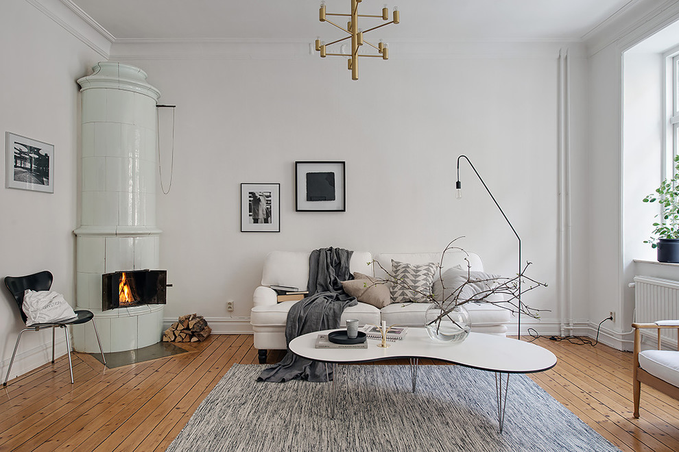 Modelo de salón para visitas abierto escandinavo de tamaño medio sin chimenea y televisor con paredes blancas y suelo de madera clara