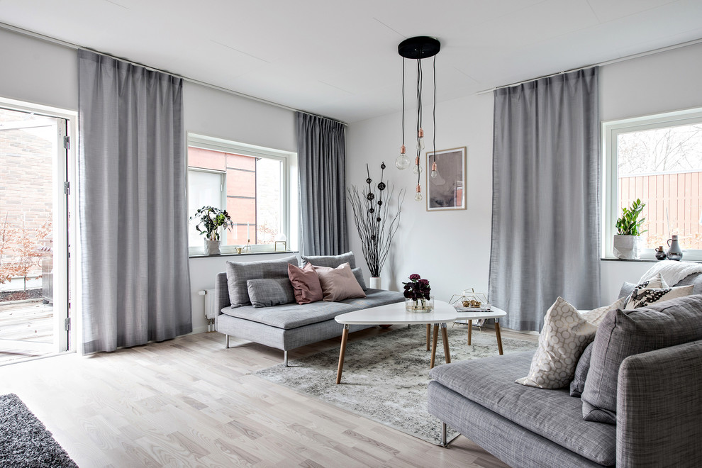This is an example of a scandinavian formal enclosed living room in Gothenburg with white walls, light hardwood flooring, no fireplace, beige floors and no tv.