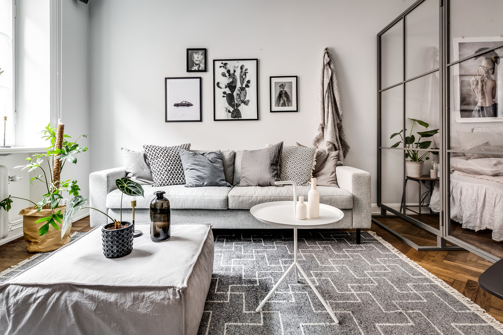 Foto di un piccolo soggiorno scandinavo aperto con pareti bianche, pavimento in legno massello medio e pavimento marrone