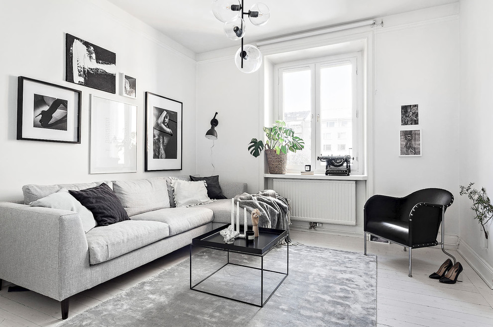 Idéer för skandinaviska vardagsrum, med vita väggar, målat trägolv, en öppen hörnspis, en spiselkrans i trä och vitt golv