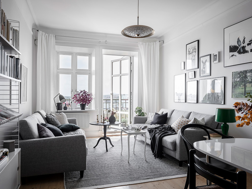 Scandinavian formal open plan living room in Gothenburg with white walls, light hardwood flooring and beige floors.