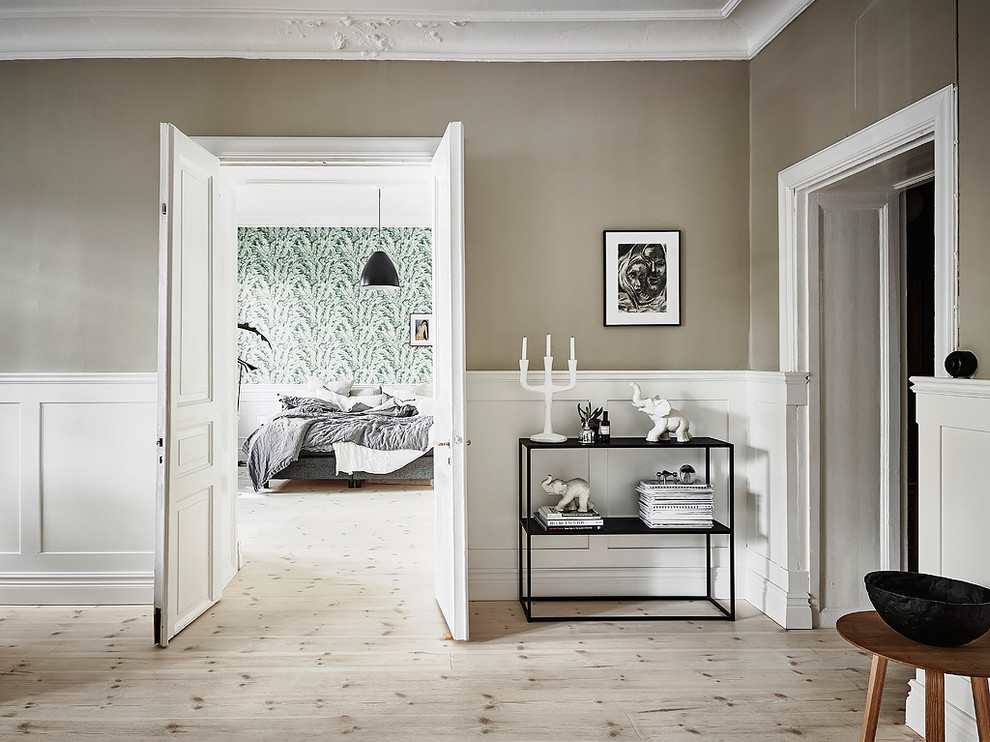 This is an example of a scandinavian living room in Gothenburg with beige walls, light hardwood flooring and beige floors.