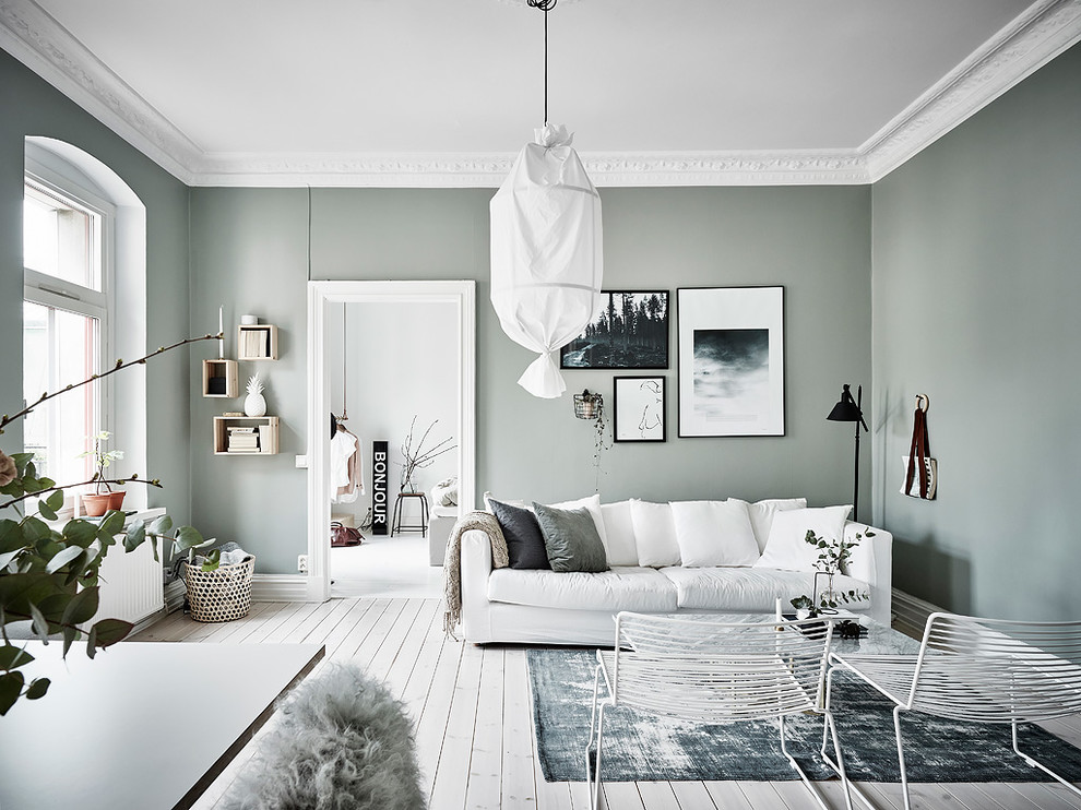 Fernseherloses, Abgetrenntes Nordisches Wohnzimmer ohne Kamin mit grüner Wandfarbe, hellem Holzboden und weißem Boden in Göteborg