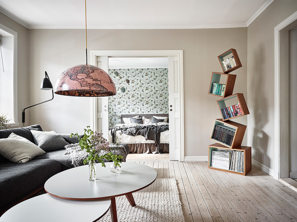 Imagen de salón escandinavo sin chimenea y televisor con paredes beige y suelo de madera clara