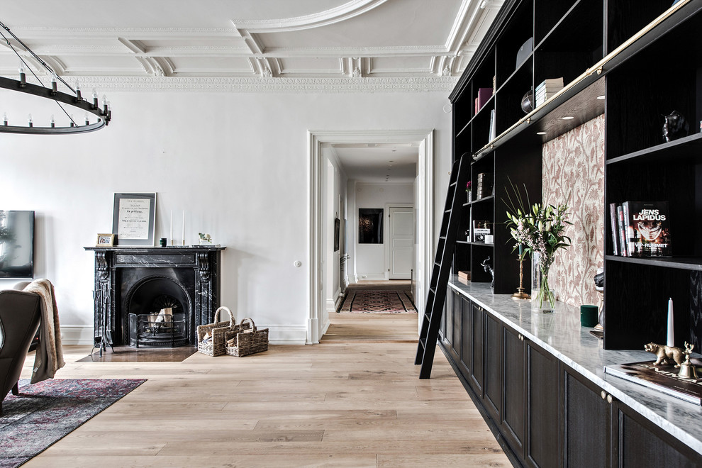 Großes Klassisches Wohnzimmer mit weißer Wandfarbe, hellem Holzboden, Kamin und Kaminumrandung aus Stein in Göteborg