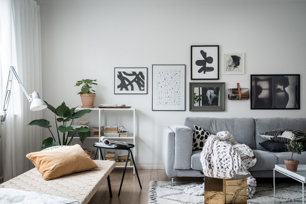 Inspiration for a mid-sized scandinavian enclosed light wood floor and beige floor living room remodel in Gothenburg with white walls and no fireplace