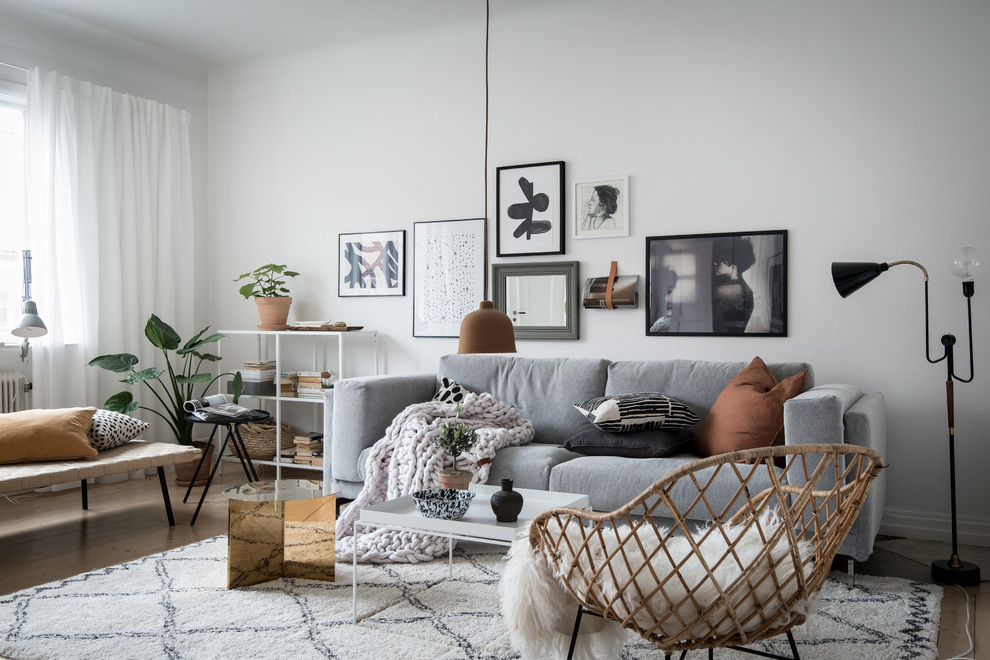 This is an example of a scandi living room in Gothenburg with white walls and light hardwood flooring.
