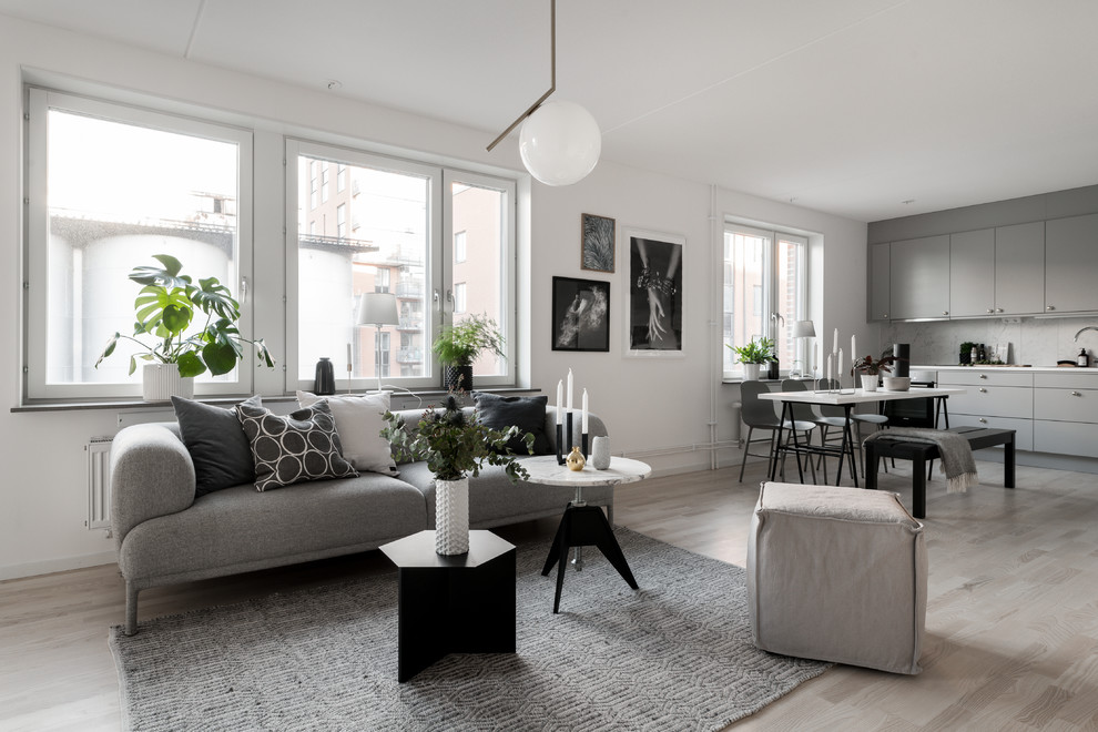 Ejemplo de salón para visitas abierto y gris y negro nórdico de tamaño medio con paredes blancas, suelo de madera clara y suelo beige