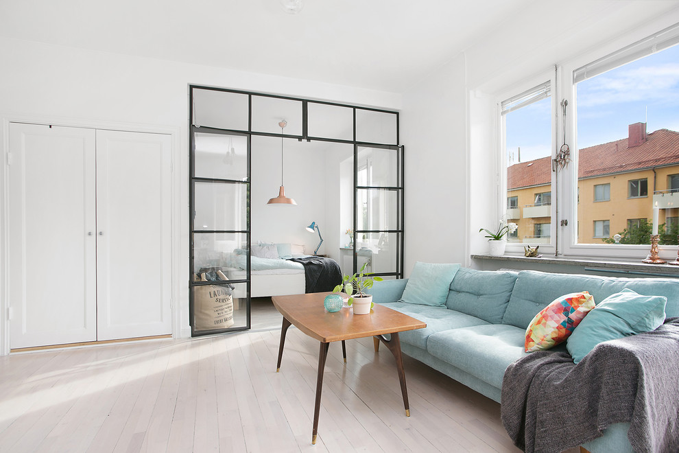 Example of a mid-sized danish formal and open concept light wood floor living room design in Stockholm with white walls and no tv