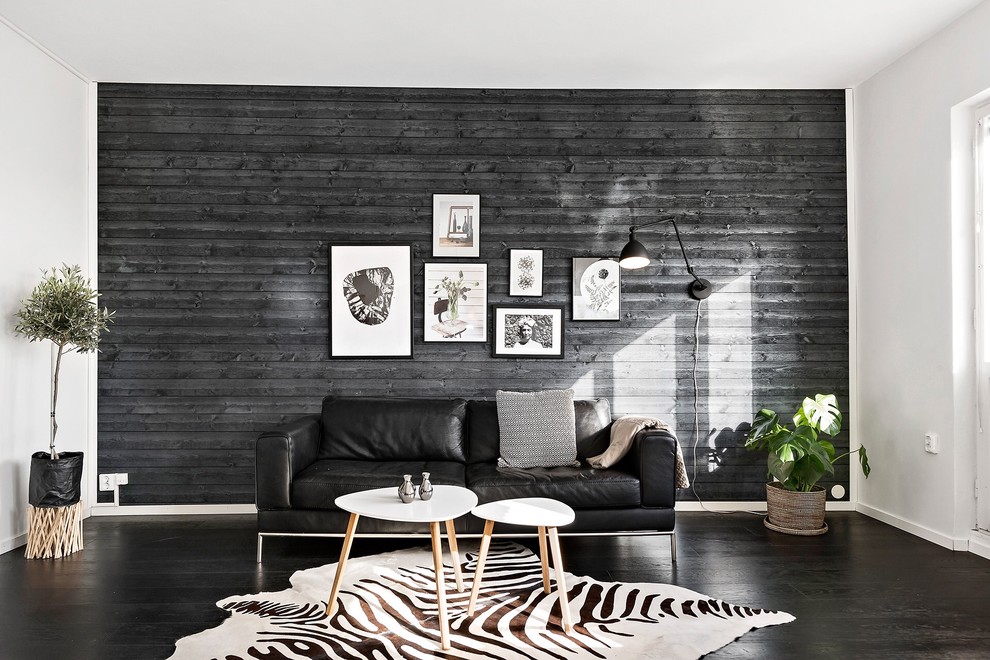 Large scandinavian open plan living room in Stockholm with black walls, black floors and dark hardwood flooring.