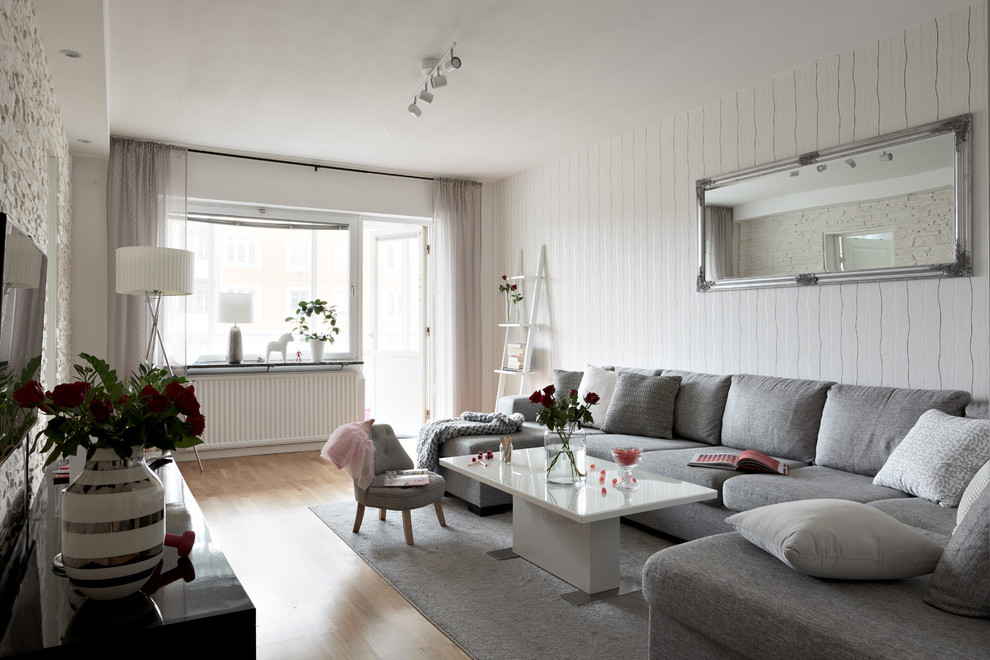 Immagine di un soggiorno nordico con pareti bianche, pavimento in legno massello medio e pavimento marrone