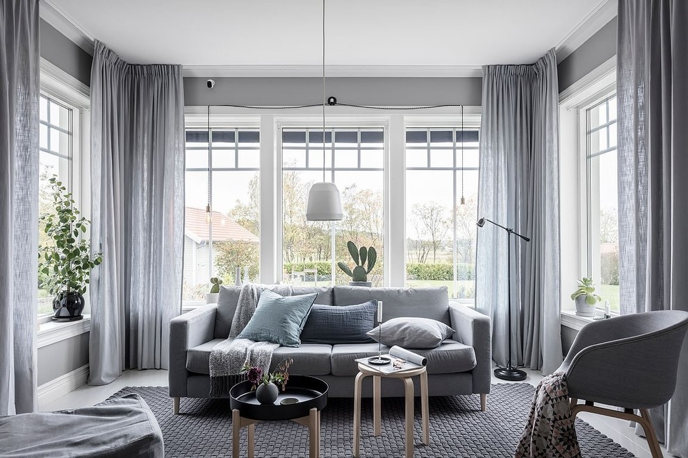 Стильный дизайн: гостиная комната в скандинавском стиле с серыми стенами и деревянным полом без камина - последний тренд