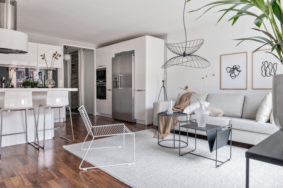 Offenes Skandinavisches Wohnzimmer mit weißer Wandfarbe, braunem Holzboden und braunem Boden in Göteborg